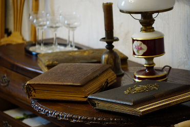 Antike Bücher mit Goldprägung, historische Petroleumlampe und Kristallgläser in der Biedermeier- und Jugendstilstube des Antik- und Trödelladens Swen Homrighausen in Bad Berleburg-Wingeshausen